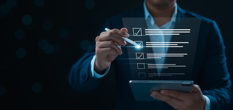 Businessman tracking business performance, businessman using tablet to check assessment questionnaire items and take online survey quizzes, paperless workplace, electronic signing network.