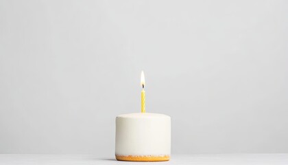 Minimalist cake with a lit candle on a plain background, perfect for celebrations and events