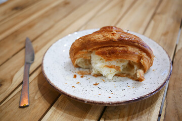 Flaky Croissant with Melted Cheese on Rustic Plate