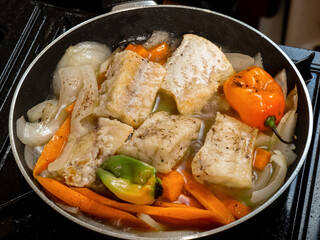 A frying pan  of Jamaican or Caribbean pickled saltfish Escovitch with salt cod, onions, carrots and 
spicy hot Scotch Bonnet Peppers