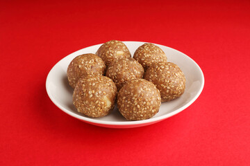 Sesame seed jaggery ball or til ke laddo and tilgul or til gul laddu served in bowl for Makar Sankranti Festival in India