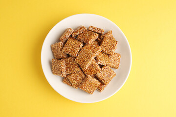 Sesame seed jaggery chikki or til ke chkki and tilgul or til gul ladduchikki served in bowl for Makar Sankranti Festival in India
