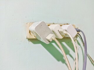 Electric socket terminal filled with cellphone charger plugs.
