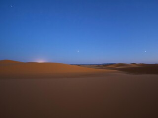 Naklejka premium Starry night in the desert with sand dunes under a clear sky filled with twinkling stars, tranquil, scenic