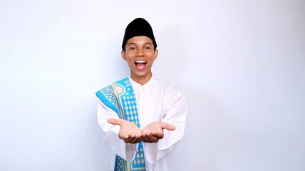 handsome asian muslim young man excited pose showing open palm for promotion, product and discount. recommend something with isolated white background