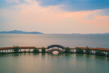Fototapeta premium An ancient building complex and sunset scenery on the Taihu Lake Lake in Wuxi, Jiangsu Province, China will be on June 3, 2024