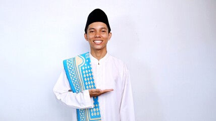 handsome asian muslim young man smiling pose showing open palm for promotion, product and discount. recommend something with isolated white background