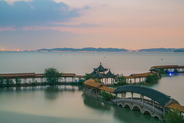 Obraz premium An ancient building complex and sunset scenery on the Taihu Lake Lake in Wuxi, Jiangsu Province, China will be on June 3, 2024
