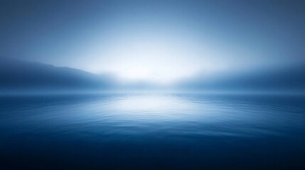 Obraz premium Serene misty lake at dawn, calm water reflecting soft light.