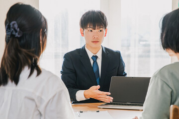 Obraz premium 家族のお客様に営業するビジネスマン A businessman selling to a family member