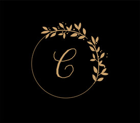 The logo has an elegant and classic design, with the main element being a monogram of the initials, such as the letters A and B, written using a calligraphy or serif font with fine details. The gold c