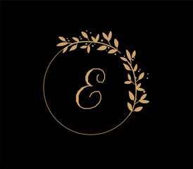 The logo has an elegant and classic design, with the main element being a monogram of the initials, such as the letters A and B, written using a calligraphy or serif font with fine details. The gold c