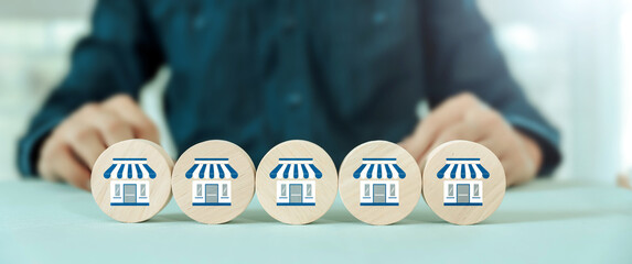 Hand choose wooden toy stack with franchise icon for goal to growth is investment planning financial and branch expansion and management plan bank loans or marketing franchising network business.