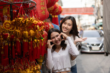 Young Asian Women Shopping for beautiful red ornament Offerings Outdoors market