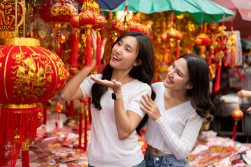 Young Asian Women Shopping for beautiful red ornament Offerings Outdoors market
