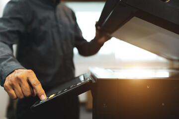 Men use photocopy or copier machine office workplace equipment for make a copy paper or photocopier for scanning document and photocopying service maintenance concepts.