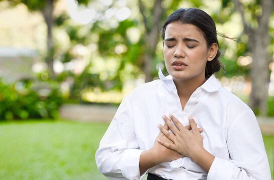 Unwell Indian woman suffering from heart condition, heart attack, irregular heartbeat