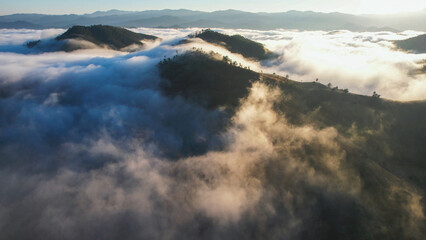 Landscape view of the sea of fog flowing on hills at dawn by drone