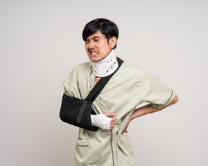 Depressed upset man suffering from pain. Broken arm. Asian man put on plaster bandage cast splint....