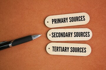 Pen and stick with the words Primary, Secondary and Tertiary Sources. Texts of laws and other...