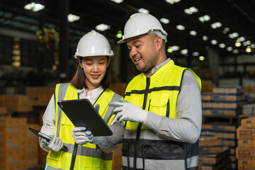 Fototapeta premium Professional engineer and technician wearing safety helmet analyzing meeting with tablet in factory warehouse. Confident factory workers group inspection industry factory. Teamwork concept.