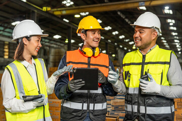 Professional engineer and technician wearing safety helmet analyzing meeting with tablet in factory warehouse. Confident factory workers group inspection industry factory. Teamwork concept.