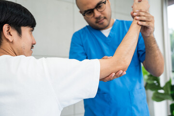 Obraz premium Physical therapy. Male Nurse aids young man in recovering from spine injury and providing orthopedic massage Orthopedic healthcare and chiropractor with person for physical therapy rehabilitation