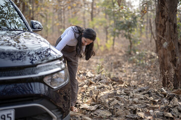 A frustrated girl near her damaged or punctured car