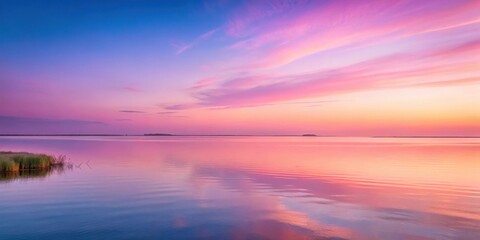 Fototapeta premium Soft pink hues illuminate the horizon as morning light slowly creeps over a serene landscape, dawn