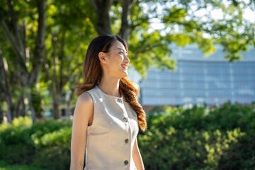 Young asian woman standing posing at public park. Happy attractive charming asian female living in...