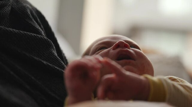 Mother comforts infant baby boy in arms fussing