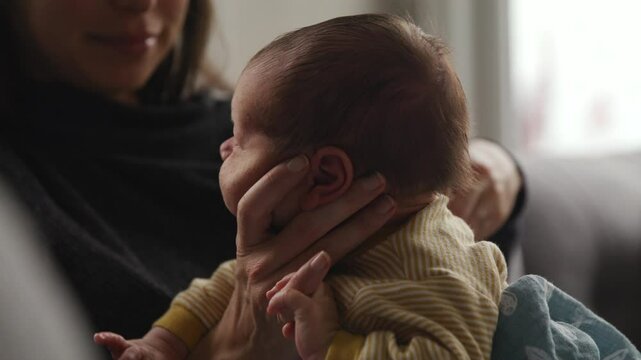 Mother burping infant baby after feeding - close up