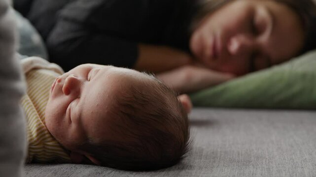 Infant boy begins to wake up as mother and baby day nap