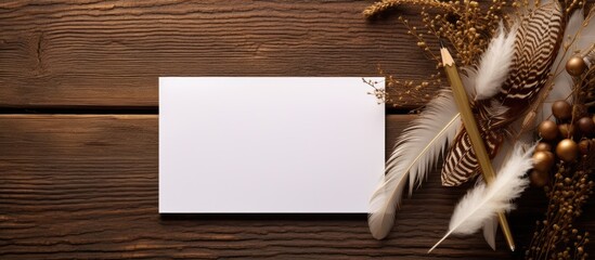 Elegant luxury pen and blank New Year card arranged on rustic wood background with natural decor elements of gold and feathers to enhance ambiance.