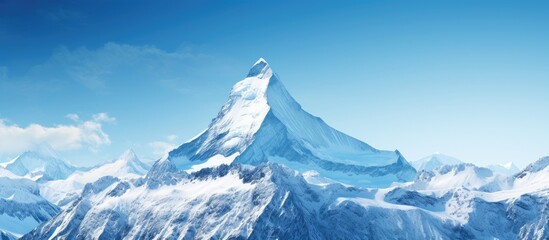 Majestic snow-capped mountain peak reaching into clear blue skies with soft white clouds gently surrounding its summit in serene landscape.