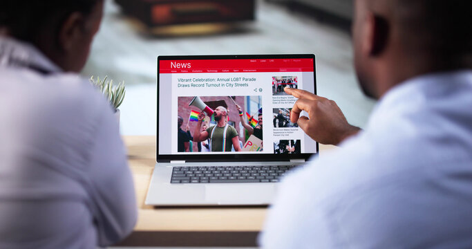 Watching Online News Article On Mobile Phone And Laptop