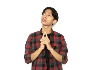 Young Asian man is thinking with eyes looking up, thinking, imagining
