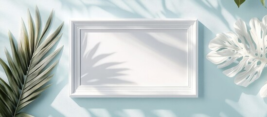 Empty white wooden frame positioned centrally against a soft blue background with gentle shadows and tropical leaf patterns for wall art mockups.