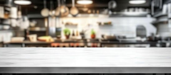 Spacious blurred kitchen interior with a white empty table in the foreground offering ample copy space for product showcasing and display.