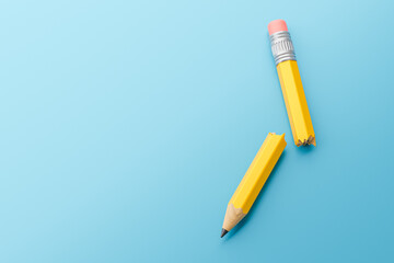 Broken pencil in half on a blue background. 3d render
