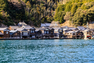 Fototapeta premium Traditional Wooden Boat Houses Lining the Waterfront in Ine, Kyoto, Japan