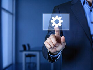 A businessman interacting with a virtual screen showcasing gear icons exemplifying the integration of business technology in modern workflows and digital innovation.