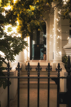 Colis d&eacute;pos&eacute; au pieds d'une jolie porte sur un porche ensoleill&eacute; le matin dans le quartier de Notting Hill en Angleterre. 
