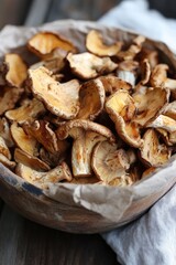 Harvested chanterelle mushrooms in rustic bowl on wooden table