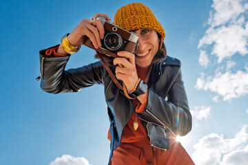 Obraz premium young girl with a camera. photographer with camera. Stylish girl with a film camera. takes a shot.