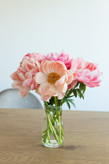 Still life with blossoming peony bouquet in a vase on table