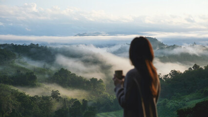 Blurred rear view of a woman looking at a beautiful foggy mountain and nature view