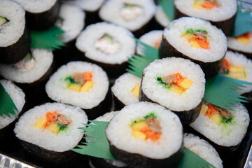Okazuya maki sushi pieces close up on Japanese deli platter