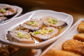 Marinated ahi tuna on display on white plate in okazuya Japanese deli