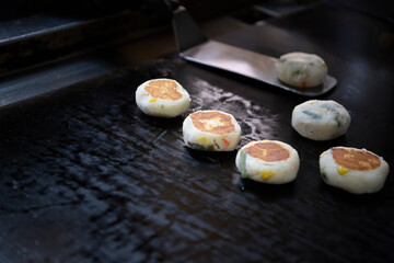 Okazuya potato vegetable hash cooking on flat black grille
